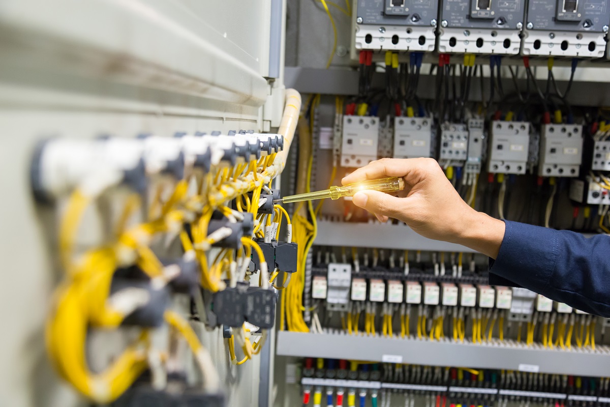 Electricians hands testing current  electric in control panel.